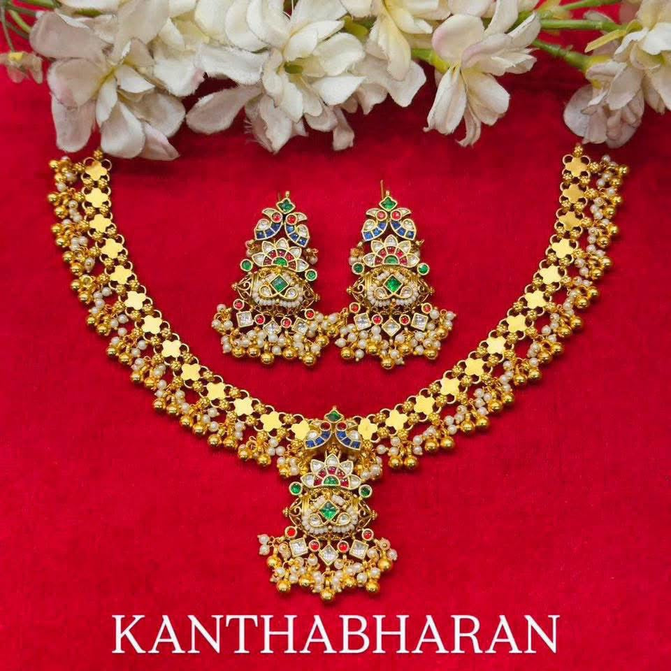 Gold-tone floral links lead to a multicolor pendant, finished with white beads and rounded drops.